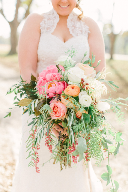 Cascading bridal bouquet by designer Christy Hulsey of Colonial House of Flowers – Statesboro, Georgia, with Coral Charm peonies, coral ranunuculus, Juliet garden roses, white ranunculus, pepper berry and privet berries