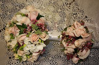 Candy Bianca roses, white phlox, white freesia, ivy, queen annes lace, and wax flower. 