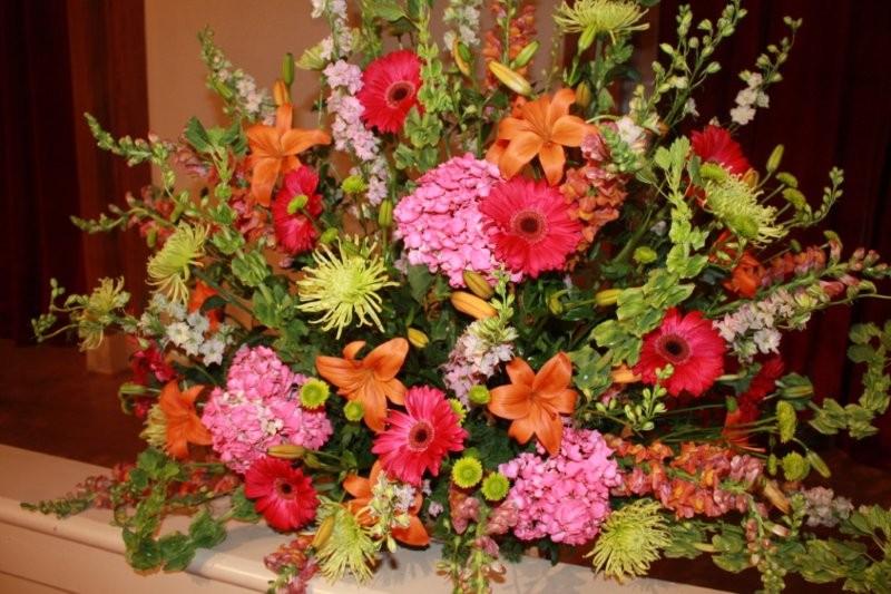 green Mums, orange Lily, pink Larkspur, raspberry Gerbers, hot pink Hydrangea, orange Snapdragons
