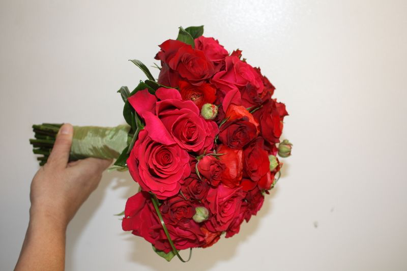  red Roses, red Ranunculus, deep pink Roses, spray Roses, Gardenia foliage.