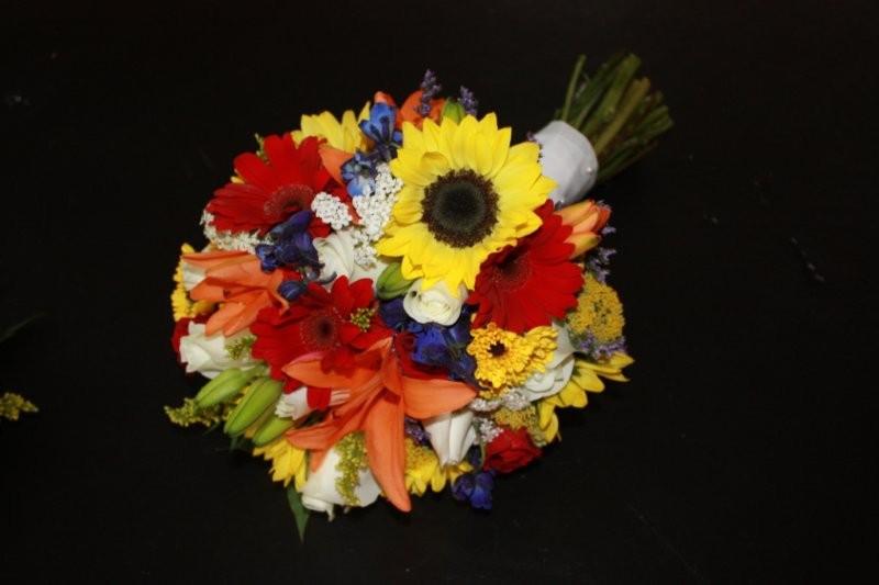 sunflower, gerber daisy, lilies, blue delphinium