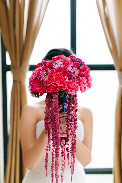 Cascading bridal bouquet by designer Maria Limon of Maria Limon Atelier - Mexico City, Mexico, with fuchsia roses, carnations and red hanging amaranthus