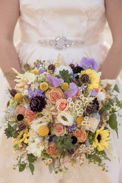 Bridal Bouquet by designer Daevid Reed of Daevids Flowers and Decor - Norfolk, Virginia, with peach roses, astilbe, craspedia, lavender sweet pea, lisianthus, chamomile, love in the mist, succulents and seeded eucalyptus