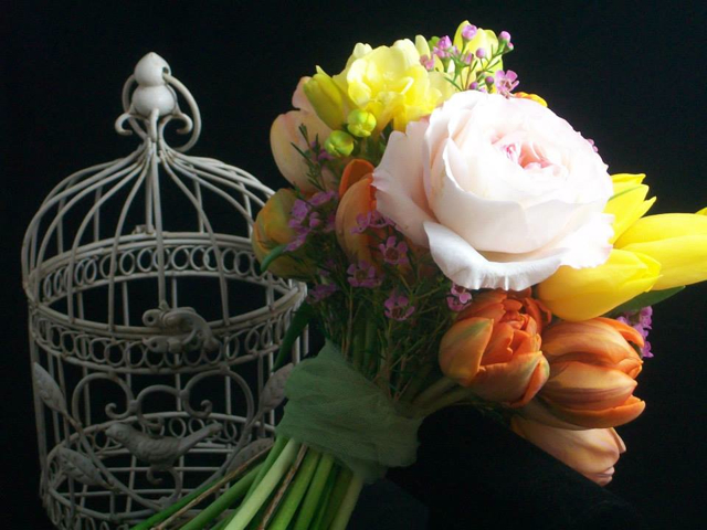 Wedding bouquet by designer Amy Santee from Amy's Wedding and Event Flowers - Aurora, Colorado, with garden roses, orange tulips, yellow tulips, freesia and wax flower