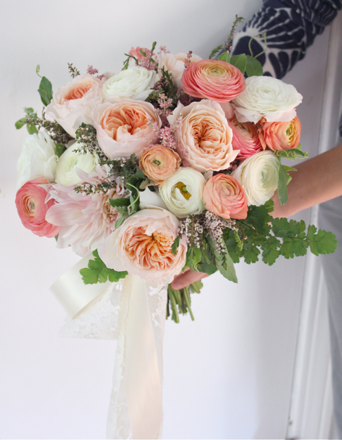 Bridal bouquet by designer Holly Rutt of Sweet Pea Floral – Michigan, with Juliet garden roses, coral ranunculus, café au lait dahlias, white ranunculus, calcynia, maidenhair fern and cascading ribbon