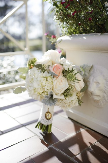 Bridal bouquet by designer Madeleine Elmer of Fleur de Vie – Houston, Texas, with white hydrangea, blush roses, white roses, white trachelium, white scabiosa, dusty miller and seeded eucalyptus