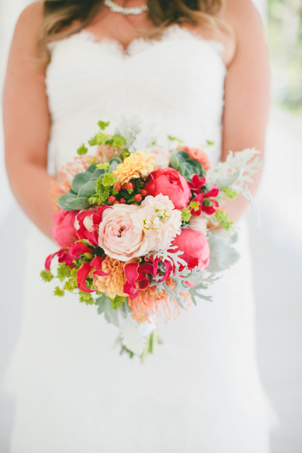 Bridal bouquet by Designer Nicole Boshard of The Petal Pusher – California, with coral charm peonies, gloriosa lilies, peach dahlias, pin cushion protea, hypericum, stock, garden roses, succulents, bupleurum and dusty miller