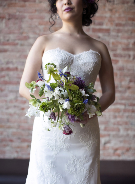 Bridal bouquet by designer Susan McLeary owner of Passionflower - Ann Arbor, Michigan, with lady slipper orchids, green ranunuculus, green hellebores, grape hyacinth, white sweet pea, purple parrot tulips, lilacs and fritillaria