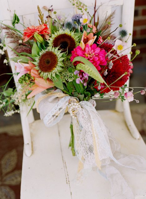 Bridal bouquet by designers Mary Coombs and Dawn Clark from A Garden Party - Elmer, New Jersey, with sun flower centers, pink zinnia, burgundy dahlias, blush Japanese anemones, coral lilies, globe thistle, poke weed, millet and vintage ribbons 