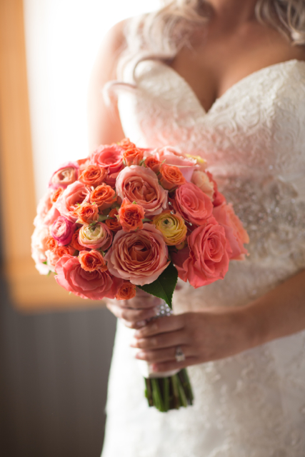 Bridal bouquet by Designers Carol and Peggy of Celebration Florals - Corvallis, Oregon, with coral and orange roses and ranunculus