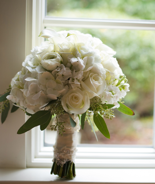 Wedding bouquet by designer Melissa Stewart of Primrose Floral and Event Design - Lexington, Massachusetts, with white hydrangea, roses, ranunculus, stock, mini callas and seeded eucalyptus