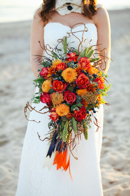 Cascading bridal bouquet by designer Alicia Jayne Florals - Southern Maryland, with orange dahlias, rust roses, yarrow, blue berries, thistle, green millet, scabiosa pods, agonis, gunnii eucalyptus, kiwi vine and cascading ribbons